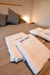 Una cama con toallas blancas encima. en Acacia Morada, en Villa Gesell