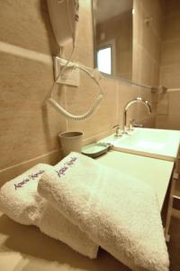un baño con toallas blancas en una encimera y un lavabo en Acacia Morada, en Villa Gesell