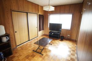 uma sala de estar com uma mesa e uma televisão de ecrã plano em GuestHouse YADOYA - Vacation STAY 08450v em Tokamachi