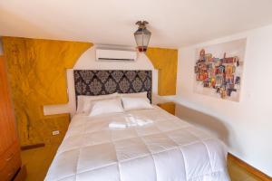 1 dormitorio con 1 cama blanca y 2 toallas en Oasis Hotel en Panamá