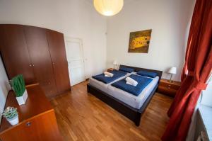 a bedroom with a bed and a wooden floor at AUTENTIC APARTMENTS Platnéřská in Prague