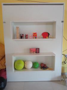 a white book shelf with balls on it at Espacio LORENZO in Arana