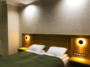 Molfar Resort Hotel & SPA في شايان: غرفة نوم بسرير اخضر مع وسادتين