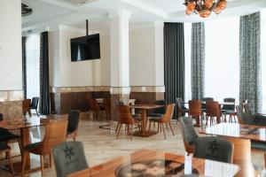 un restaurante con mesas y sillas y TV de pantalla plana en Molfar Resort Hotel & SPA en Shaian