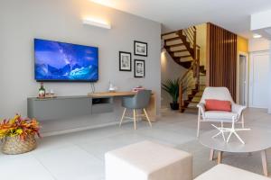 sala de estar con TV grande en la pared en Eden Roc Villas en Le Diamant