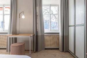 Schlafzimmer mit einem Schreibtisch und einem Fenster in der Unterkunft Smart Suites Kaltern - Apartments am Kalterer See in Kaltern
