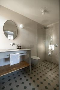 ein Badezimmer mit einem Waschbecken, einem WC und einem Spiegel in der Unterkunft Smart Suites Kaltern - Apartments am Kalterer See in Kaltern