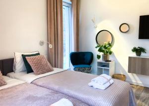 2 Betten in einem Zimmer mit einem Spiegel und einem Stuhl in der Unterkunft Chummy House Sopot in Sopot