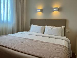 a bedroom with a large bed with white pillows at Quarto plus no Linhares Design Hotel ES in Linhares