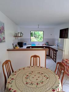 cocina con mesa, sillas y mesa en Hébergement Les HIBISCUS, en Trois-Rivières