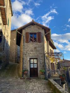 ein altes Steingebäude mit einer Tür und einem Fenster in der Unterkunft Casa Armandina - Tuscan ToBe in Santa Fiora