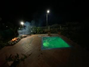 una piscina en medio de un patio por la noche en Bella casa de campo, con Hidrospa y zonas verdes, en Piedecuesta