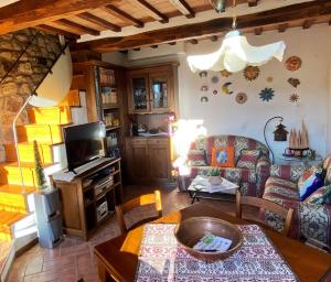 ein Wohnzimmer mit einem Sofa und einem TV in der Unterkunft Casa Armandina - Tuscan ToBe in Santa Fiora