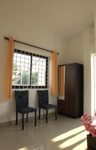 een woonkamer met 2 stoelen en een raam bij Iksa in Mandrem