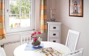 a white table with a vase of flowers on it at Amazing Apartment In Faberg-heidesee With Wifi in Oberohe