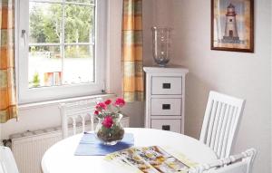 ein weißer Tisch mit einer Vase Blumen drauf in der Unterkunft Nice Apartment In Faberg-heidesee With 1 Bedrooms, Wifi And Outdoor Swimming Pool in Oberohe