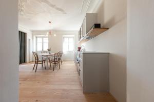 eine Küche und ein Esszimmer mit einem Tisch in der Unterkunft Smart Suites Kaltern - Apartments am Kalterer See in Kaltern