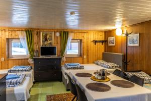 une salle à manger avec des tables, des chaises et une télévision dans l'établissement Maple House - Sodyba Tarp Klevų, à Utena