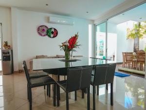 a dining room with a glass table and chairs at Spacious Luxury Home in Cancún
