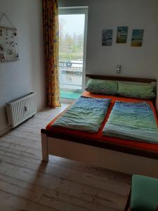 a bed sitting in a room with a window at Hafenblick in Ueckermünde