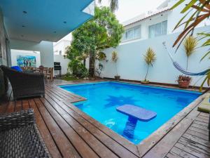 a swimming pool with a wooden deck and a house at Spacious Luxury Home in Cancún