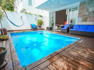 a swimming pool in the middle of a patio with blue chairs at Spacious Luxury Home in Cancún