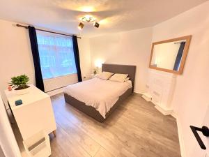 - une chambre avec un lit et une grande fenêtre dans l'établissement Modern apartment in Fulham, à Londres