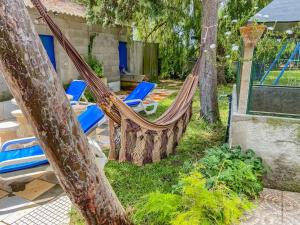 een hangmat in een tuin met stoelen en bomen bij Quinta dos Pinheiros in Estanqueiro
