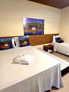 a hotel room with two beds with white sheets at Arena Carneiros Hotel by AFT in Tamandaré