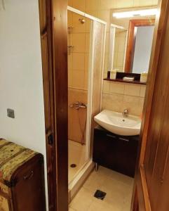 a small bathroom with a sink and a shower at Μaisonette Christina in Palaios Agios Athanasios