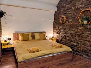 a bed in a room with a brick wall at The Industrique Home - 3 Bedroom Apartment in Timişoara