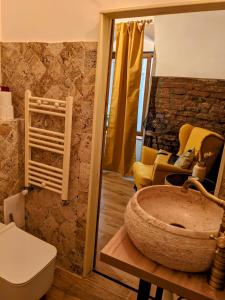 y baño con lavabo de piedra grande y aseo. en The Industrique Home - 3 Bedroom Apartment, en Timisoara
