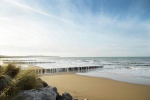 una playa con el océano y un muelle de madera en Le Marsouin, en Sangatte
