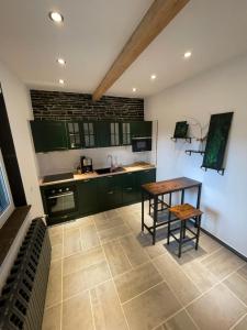 Nohra的住宿－Fewo Zur Wache，厨房配有绿色橱柜和木桌