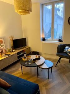 a living room with a blue couch and a table at Maison Hyper centre-Hôpital et parking in Moulins