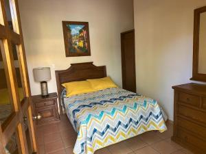 a bedroom with a bed with a colorful comforter at Hotel Plaza del Sol in Malinalco