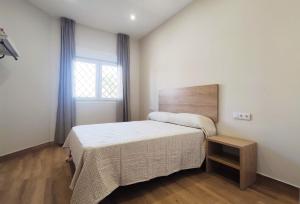 a small bedroom with a bed and a window at APARTAMENTOS SANLUCAR CASA A in Sanlúcar de Barrameda