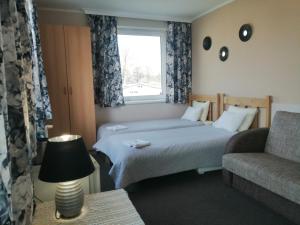 ダルウフコにあるPensjonat Landrynkaのベッドルーム1室(ベッド1台、ソファ、窓付)