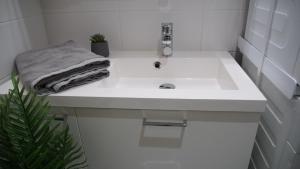 a white bathroom sink with a towel on it at City center brand new studio, parking in Oulu