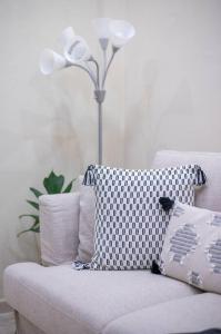 un sofá blanco con almohadas y una lámpara en la habitación en Cozy Suite 8 en la Zona Colonial, en Santo Domingo