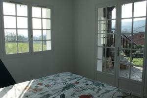1 dormitorio con cama y ventana con vistas en Gîte Chez Louve Bleue 3 étoiles-Label Tourisme et Hand, en Le Grand-Abergement