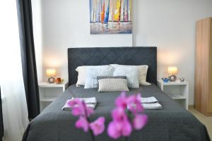 ein Schlafzimmer mit einem Bett mit rosa Blumen drauf in der Unterkunft West in apartments in Čačak