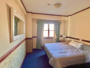a small bedroom with a bed and a window at Viejo lobo 203 in Ushuaia