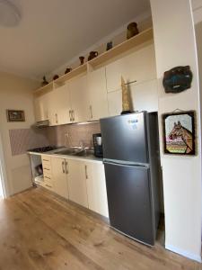 a kitchen with a stainless steel refrigerator and white cabinets at Central Park Rooms in Tirana