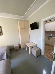 a room with a bed and a table and a kitchen at Central Park Rooms in Tirana