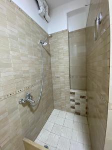 bagno con doccia e pavimento piastrellato di Central Park Rooms a Tirana