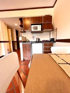 a small kitchen with a table and a microwave at Viejo lobo 203 in Ushuaia