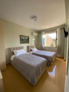 two beds in a bedroom with a window at Central Park Rooms in Tirana