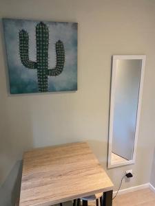una habitación con una mesa y una pintura de cactus en la pared en Cambrai:studio style loft, en Cambrai
