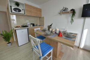 eine Küche mit einem Tisch und einer Theke mit Stühlen in der Unterkunft West in apartments in Čačak